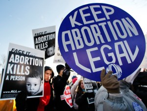 Anti-abortion and abortion activists stand side by side in front of the U.S. Supreme Court, in Washington, Monday, Jan. 24, 2011, during a rally against Roe v. Wade on the anniversary of the U.S. Supreme Court decision.  (AP Photo/Manuel Balce Ceneta)